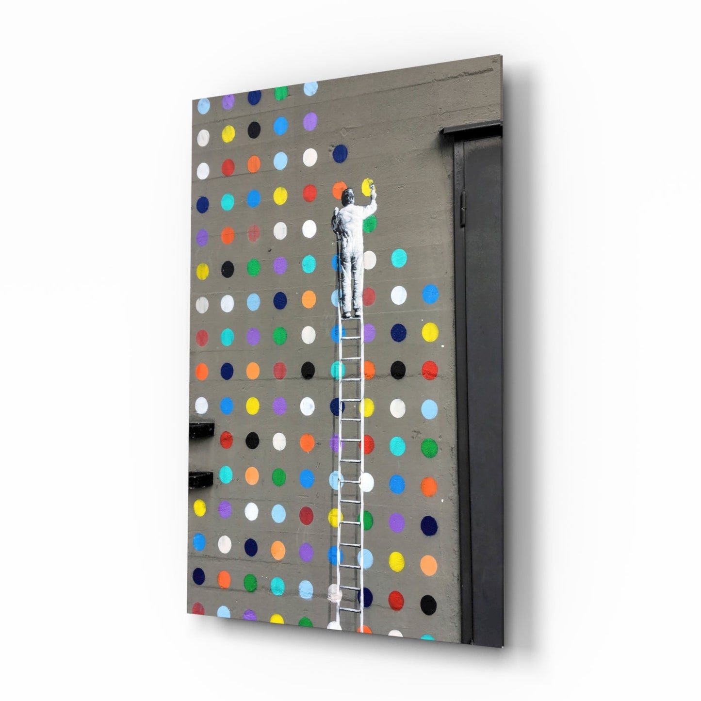 Angled view of gray pegboard wall art with multicolored painted dots and stenciled figure climbing white ladder.