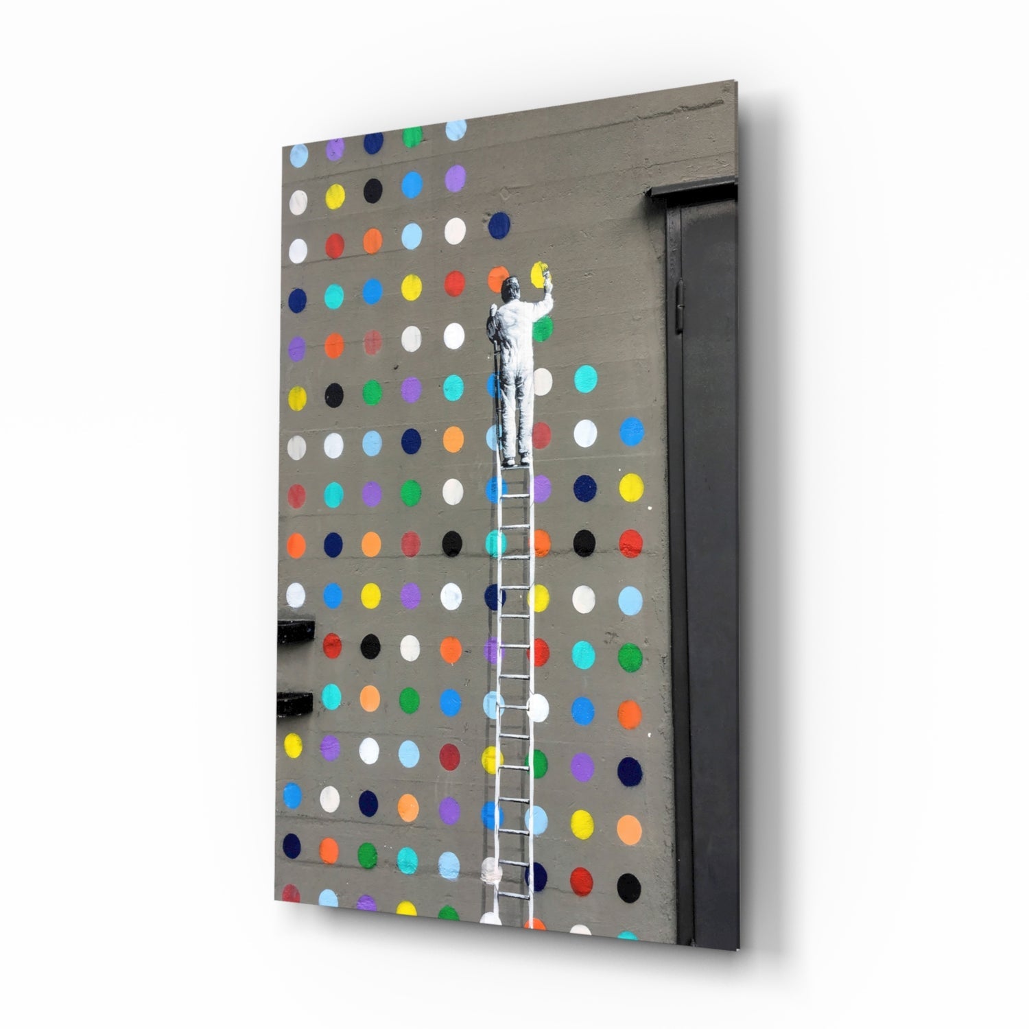 Angled view of gray pegboard wall art with multicolored painted dots and stenciled figure climbing white ladder.