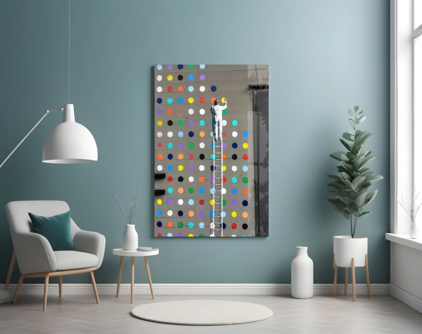 Colorful glass dot artwork displayed on turquoise wall above white chair, showing figure on ladder against multicolored circular dots on gray background.