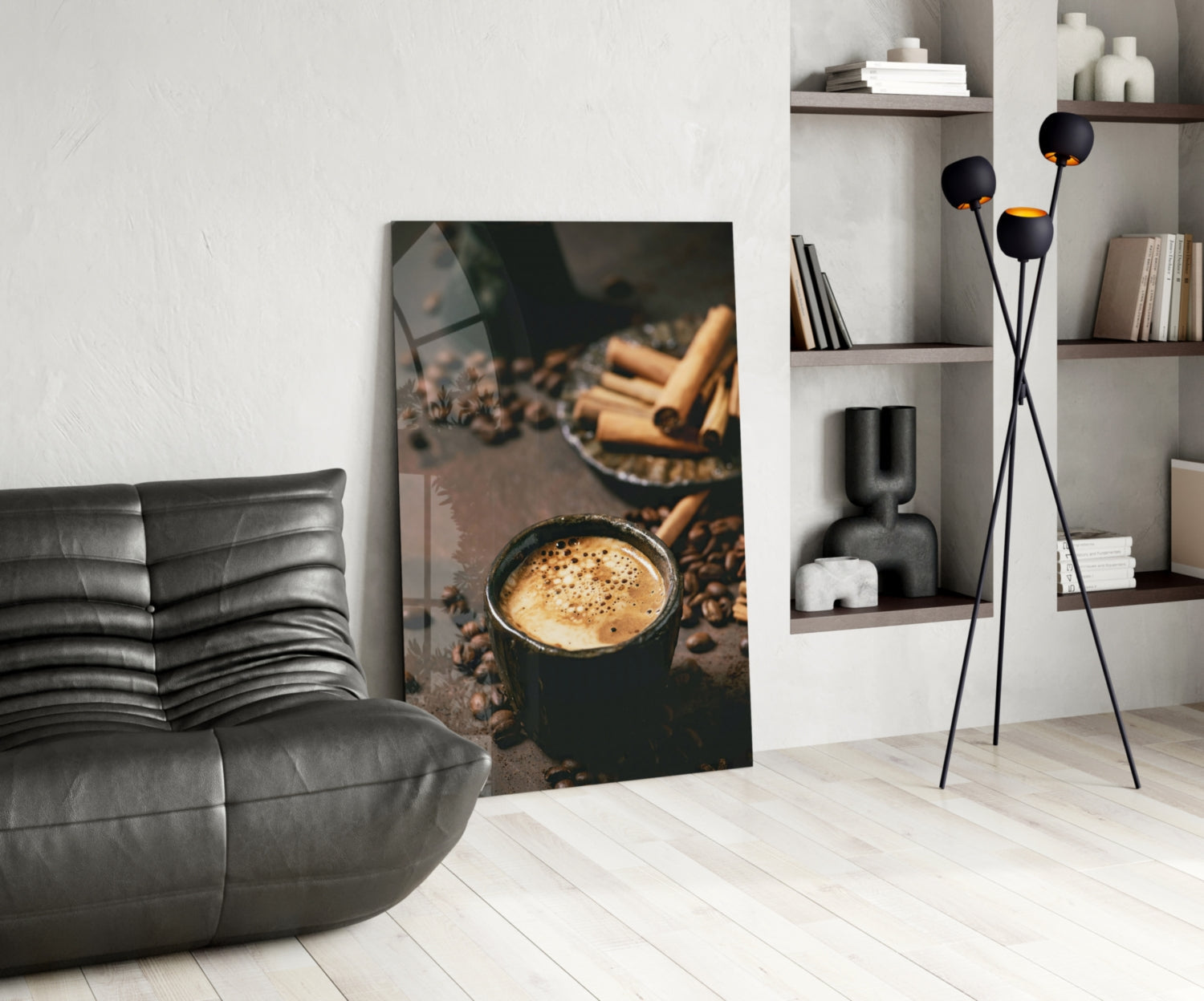 Cinnamon Coffee glass art leaning against wall in modern living room with gray sofa and shelving.