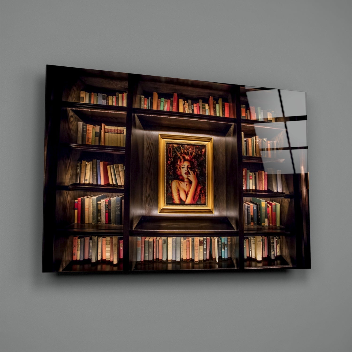 Dark wooden bookshelf with colorful books and gold-framed portrait of woman in center, displayed on glass art panel against gray wall.