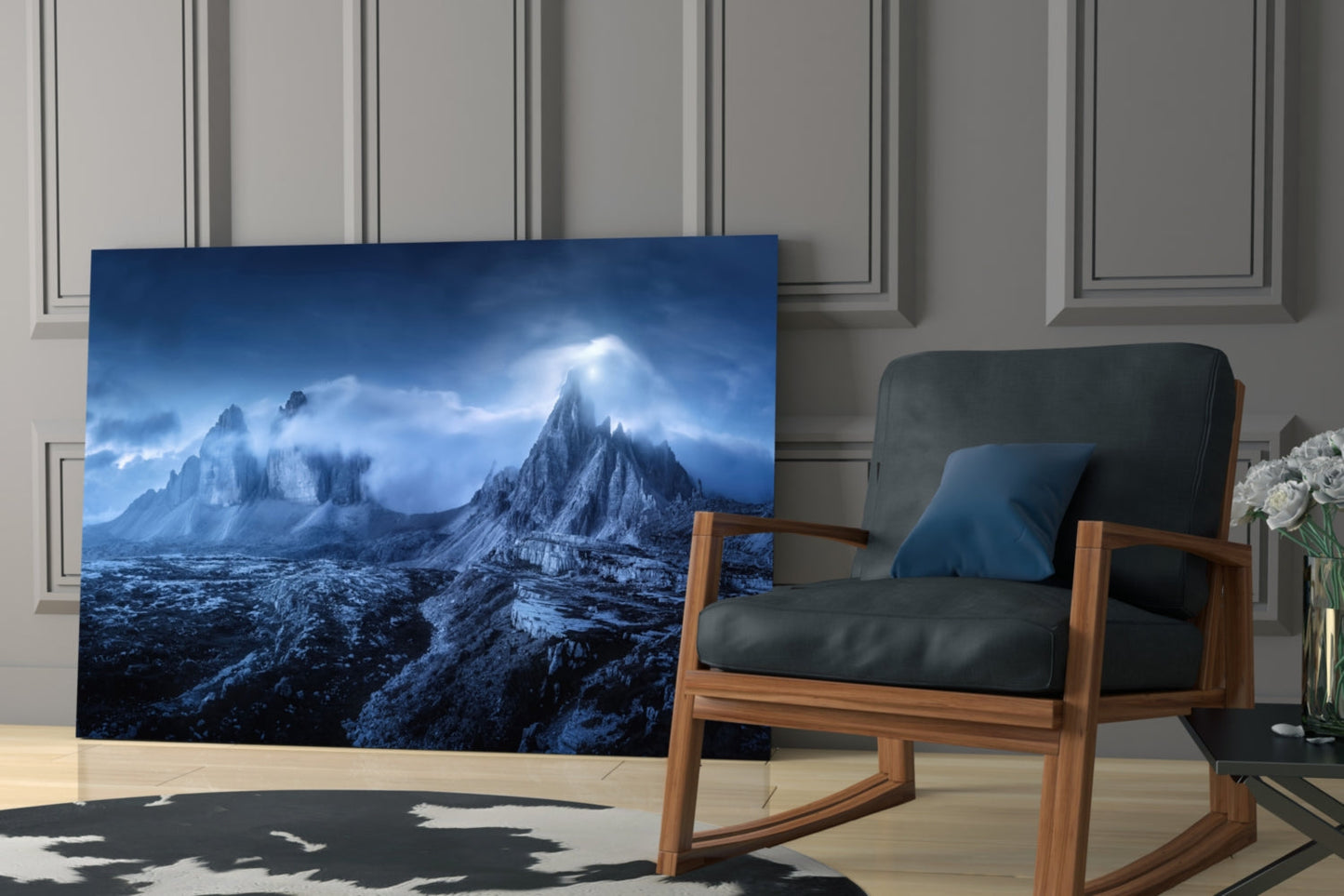 Glass art panel displaying snow-capped mountains under blue sky with divine light rays, positioned in modern living room beside wooden chair.