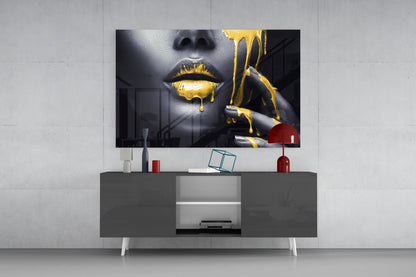 Modern living room display showing gold dripping lips glass wall art mounted above gray media console with red accents.