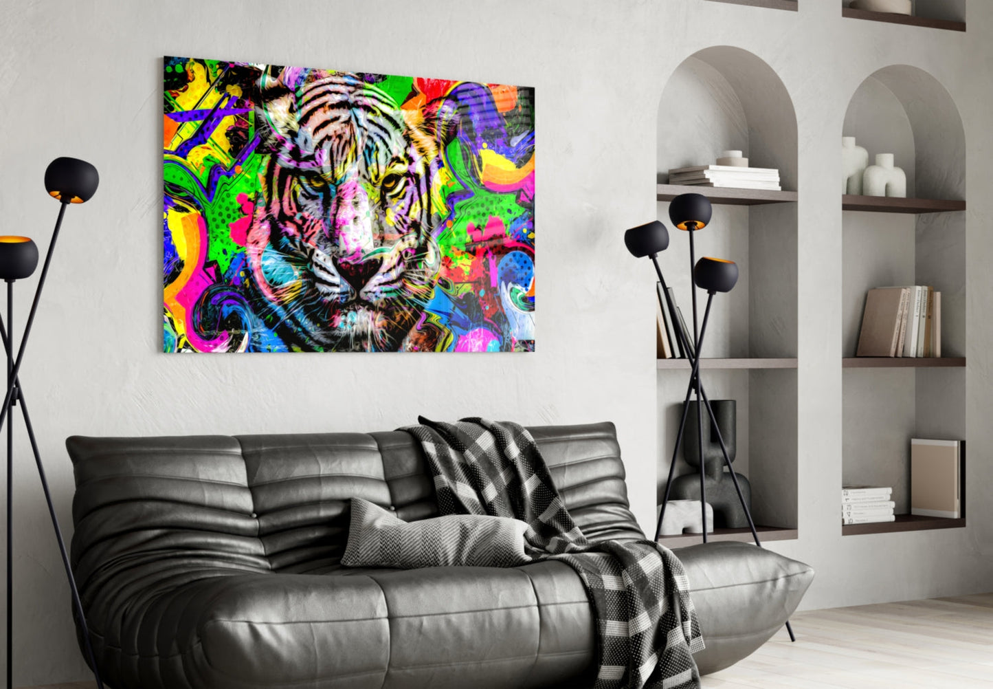 Colorful pop art tiger canvas hanging above black leather sofa in modern living room with white shelving.