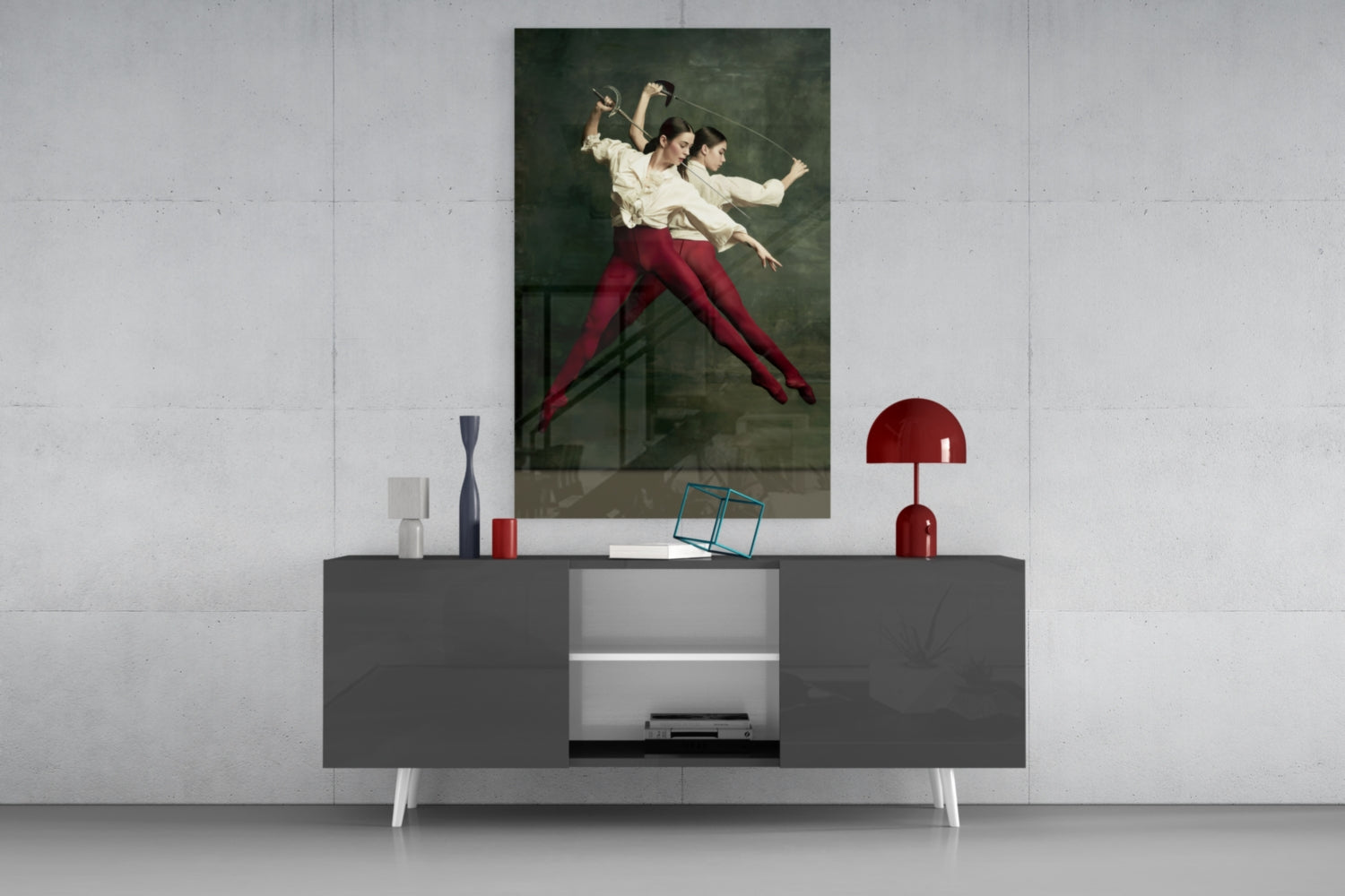 Fencing glass wall art depicting two fencers in cream shirts and red pants displayed above a gray console table with decorative accessories.