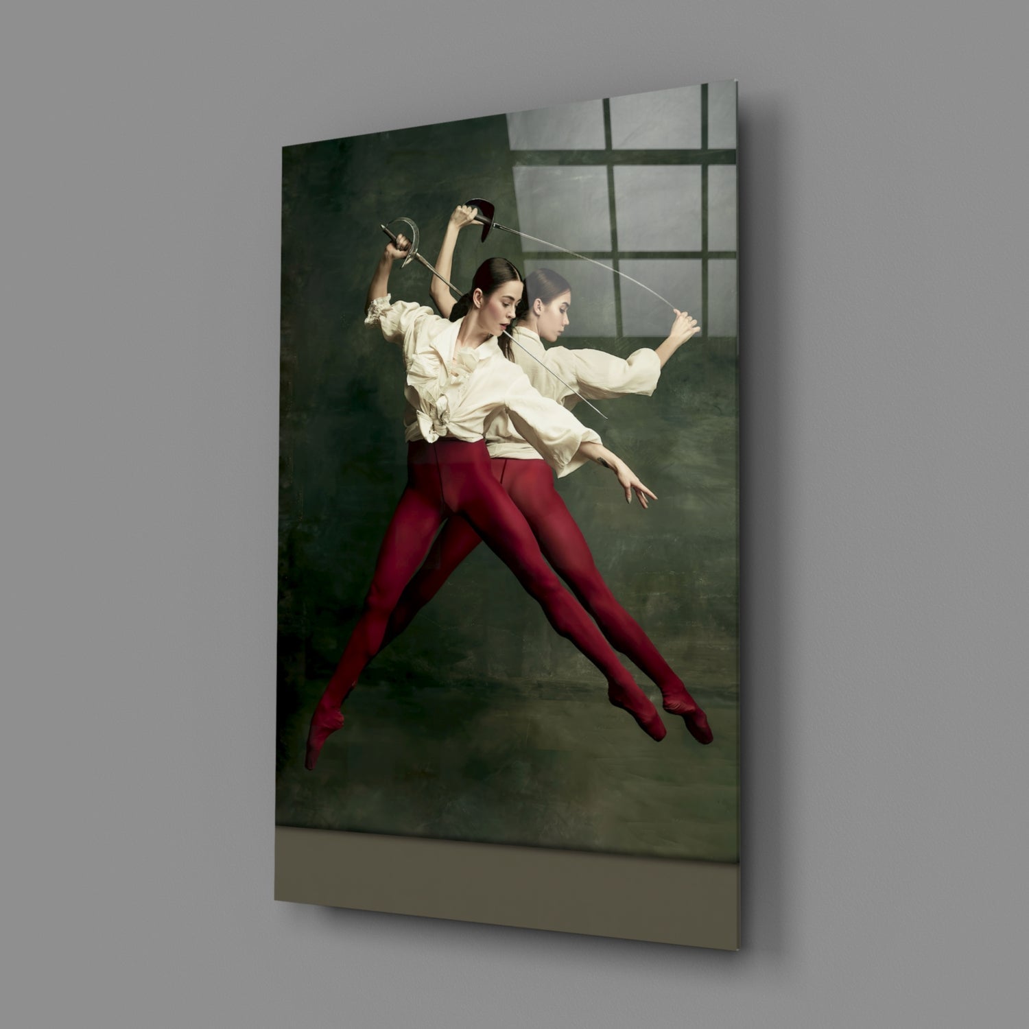 Glass wall art panel displaying two fencers in white shirts and burgundy pants leaping mid-duel against a dark green background.