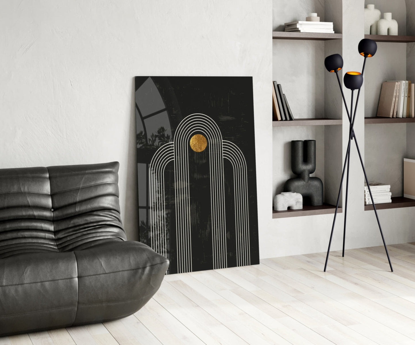 Modern living room with black leather sofa, black and white striped arch artwork with gold circle, and black tripod floor lamp with sphere heads.