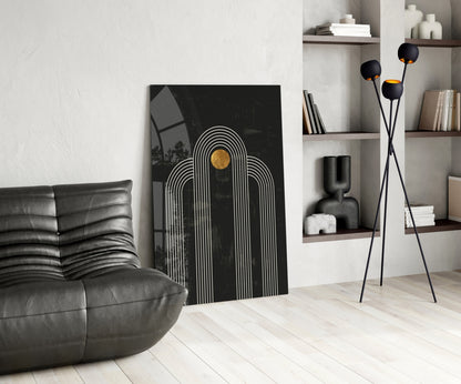 Modern living room with black leather sofa, black and white striped arch artwork with gold circle, and black tripod floor lamp with sphere heads.