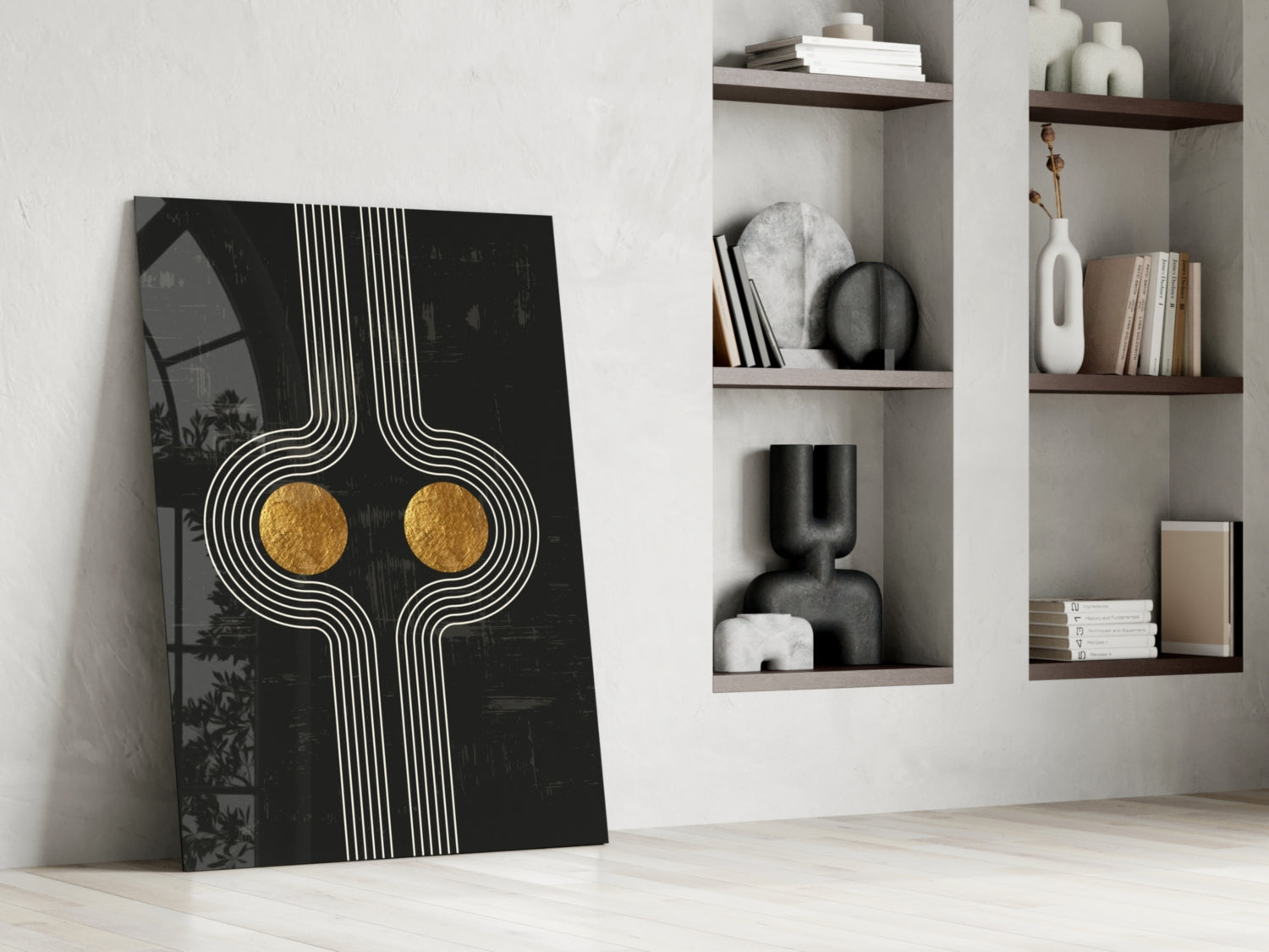 Modern minimalist interior with leaning abstract black glass art featuring white geometric lines and gold circular accents, beside white wall shelving displaying books and decorative objects.