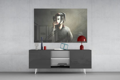 Glass wall art featuring dramatic figure holding theatrical masks displayed above modern dark sideboard with red lamp and accessories.