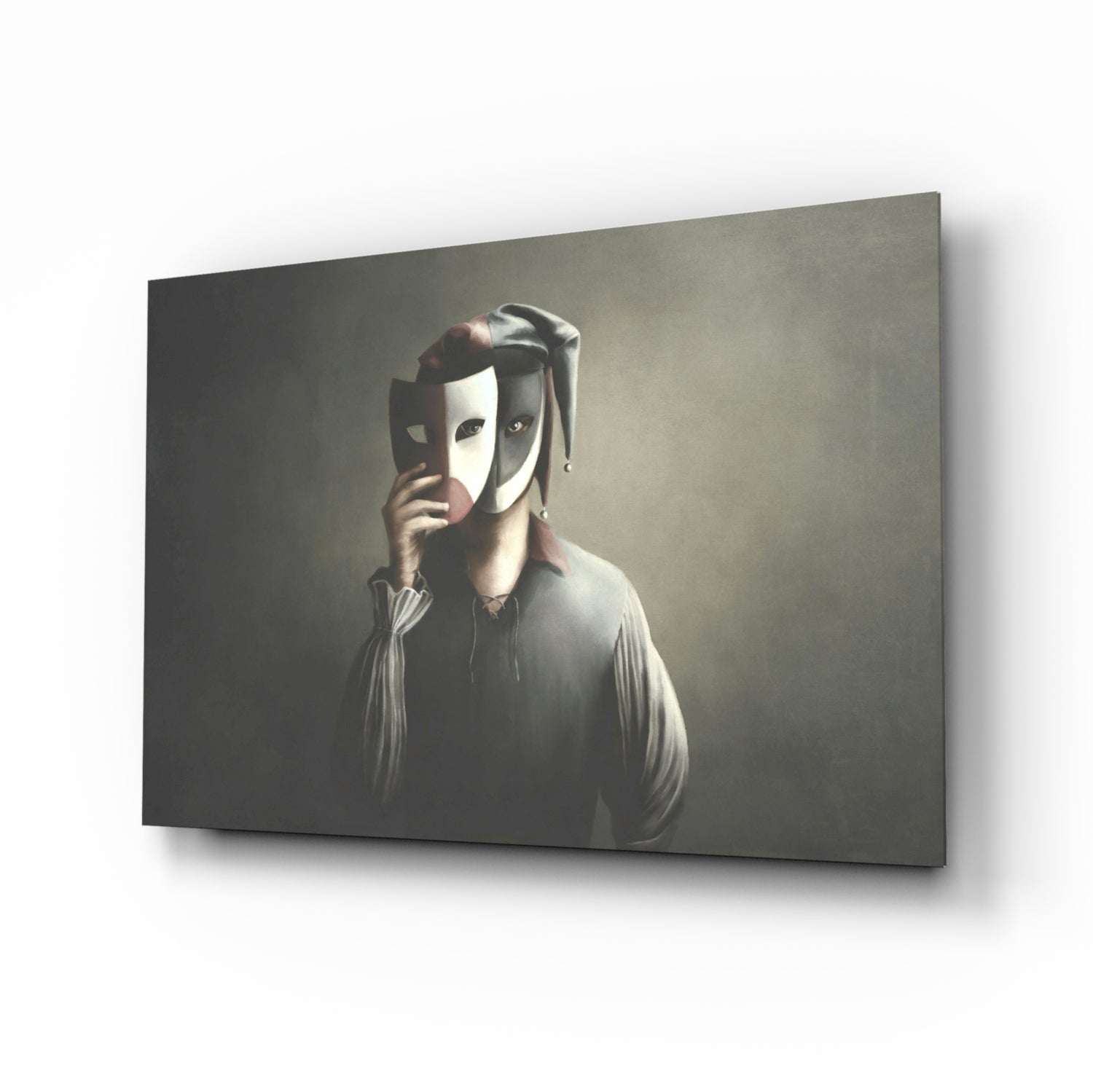 Angled view of glass wall art depicting a figure in light clothing holding theatrical masks against a muted grey background.