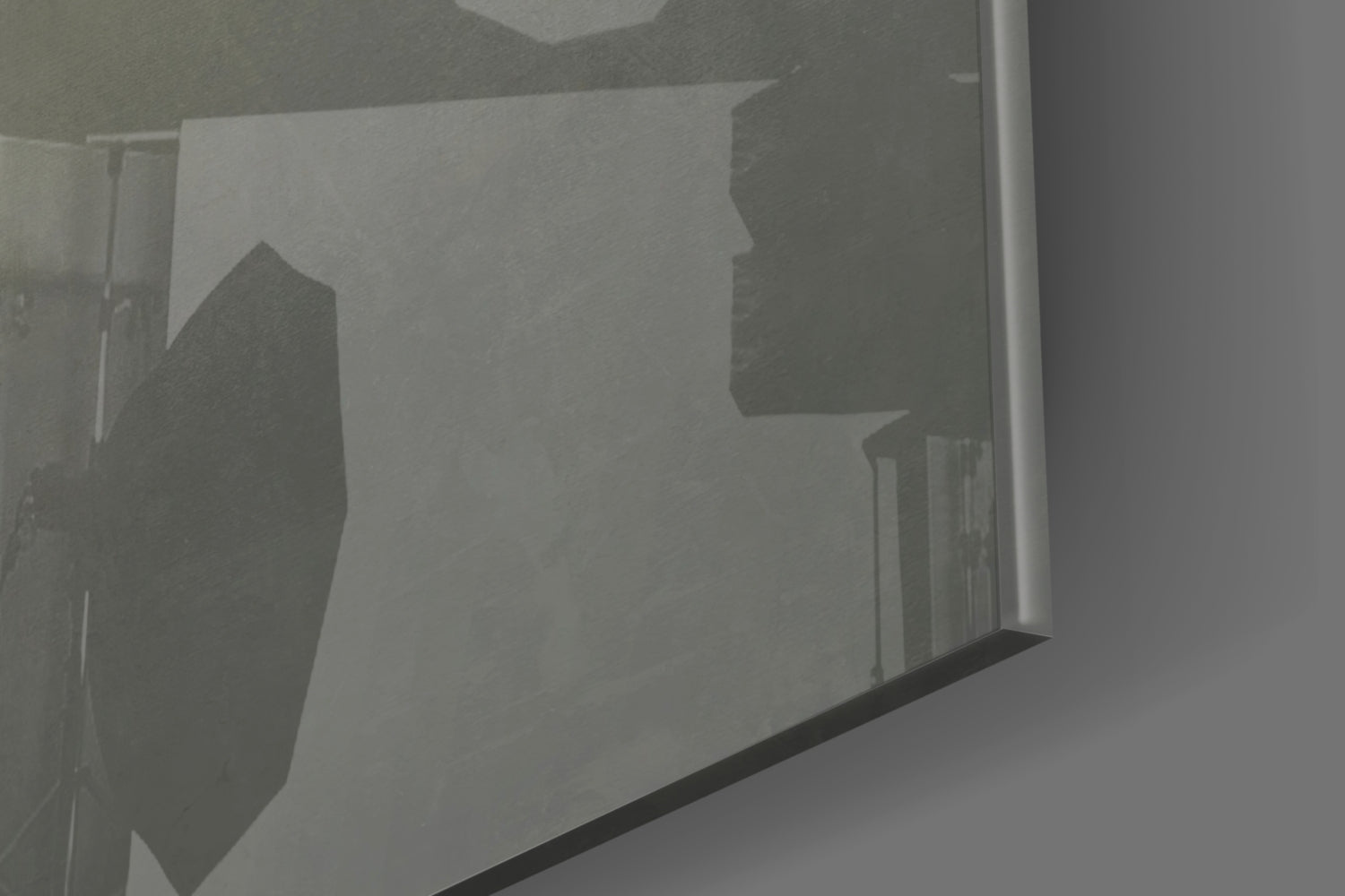Close-up detail of frosted glass wall art showing silhouetted mask profiles etched into translucent surface with dark frame edge visible.