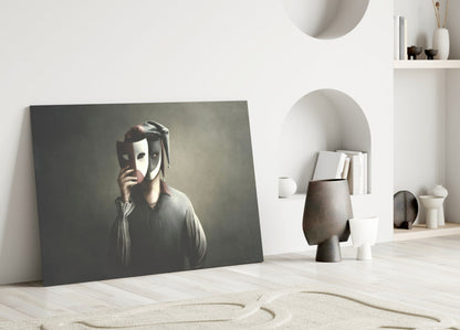 Masks glass wall art leaning against white wall in minimalist interior with shelving and decorative objects.