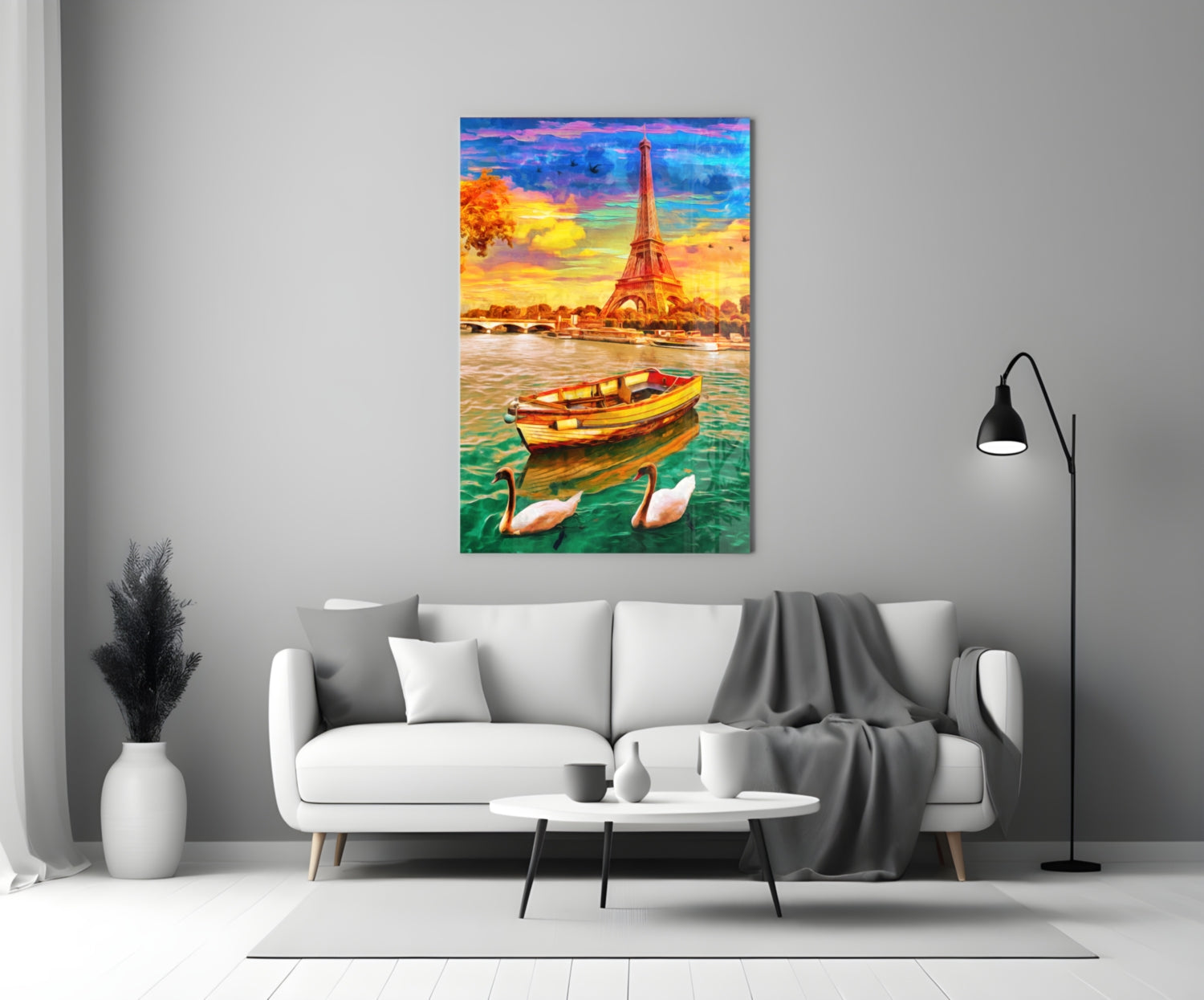 Colorful glass wall art depicting the Eiffel Tower at sunset with a yellow boat and swans on turquoise water, displayed above a white sofa in a modern living room.