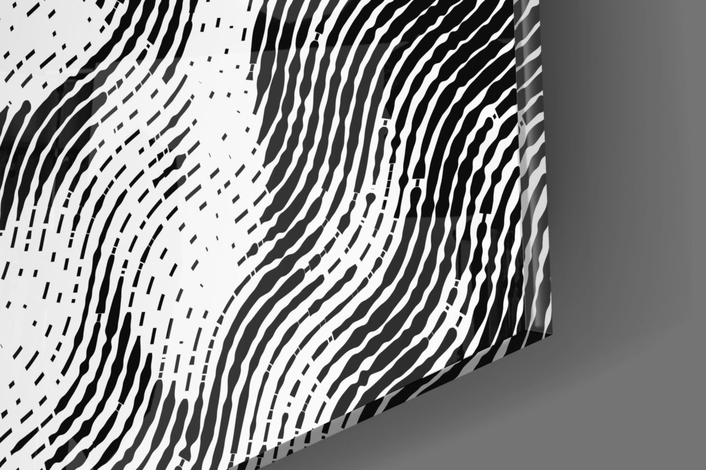 Close-up angled view of textured glass wall art with black wavy lines and patterns on white surface.