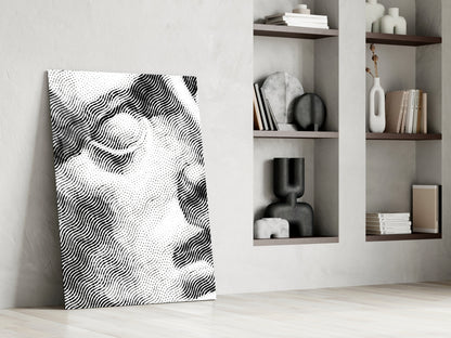 Black and white wavy striped glass wall art leaning against white wall beside wooden shelving unit with decorative objects.
