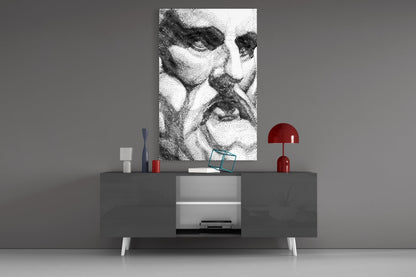 Black and white wavy line pattern glass art displayed above gray media console with red lamp and decorative accessories.