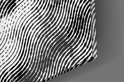 Close-up angled view of textured glass wall art with black and white wavy line patterns creating dimensional relief effect.