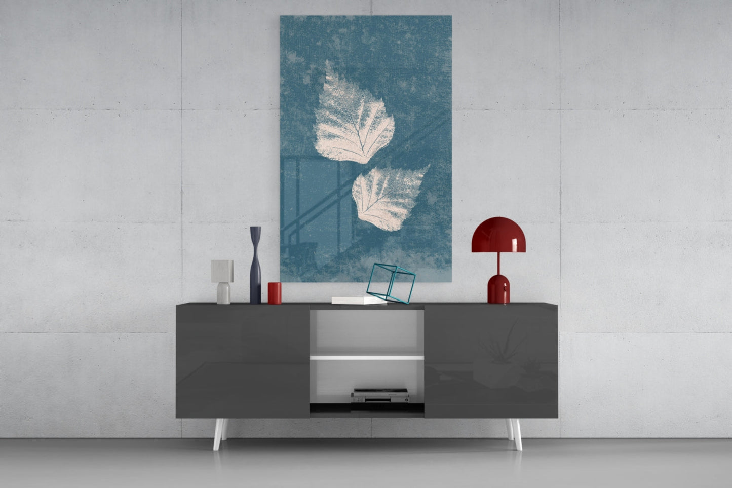 Teal glass wall art with white leaf designs displayed above a dark media console with red and white decorative accessories.
