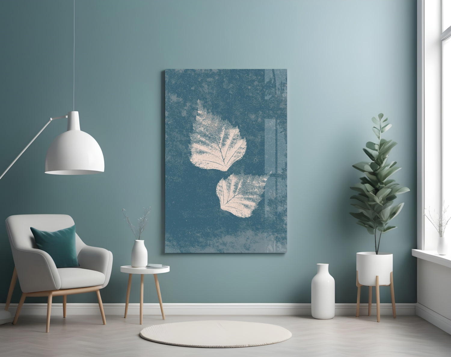 Blue-toned glass wall art featuring two cream-colored leaf prints displayed in a minimalist room setting with furniture and plants.