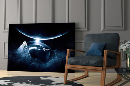 Black framed wall art displaying an astronaut in a glowing helmet facing two planets in space, displayed in a modern living room setting.