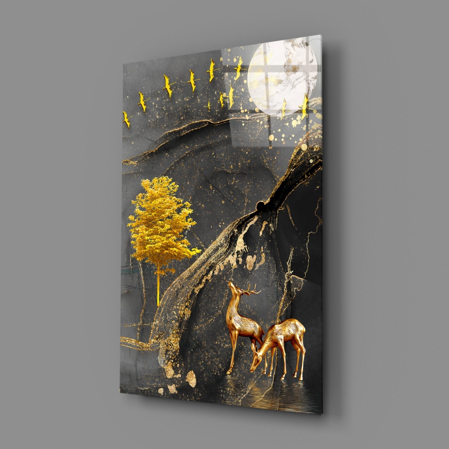 Modern glass wall art angled to show depth, featuring golden gazelles, tree, and flying birds against dark background with gold accents.