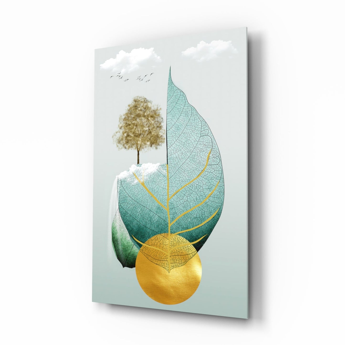 Glass wall art displaying a stylized tree within an oversized leaf, featuring teal, gold, and natural tones against a pale blue background.