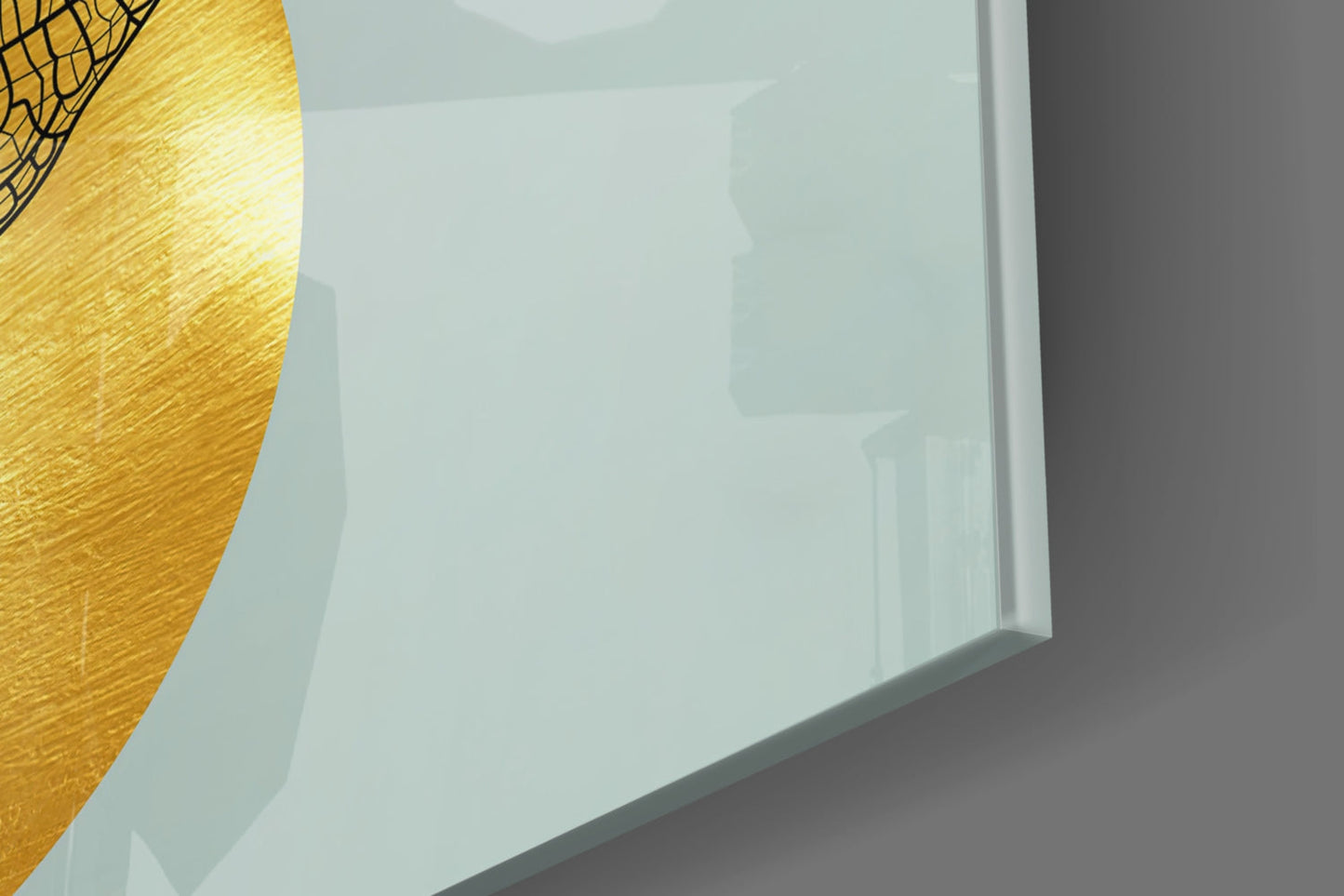 Close-up angled view of frosted glass wall art with golden textured leaf detail in upper left corner against white background.