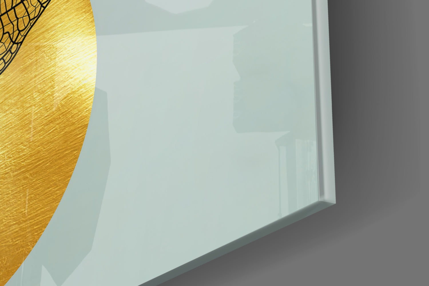 Close-up angled view of frosted glass wall art with golden textured leaf detail in upper left corner against white background.