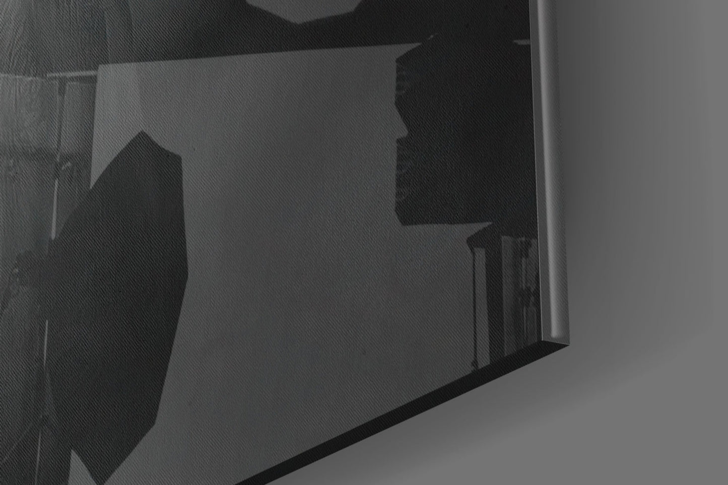 Close-up angled view of translucent glass panel displaying silhouetted hat design in black against grey background.