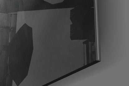 Close-up angled view of translucent glass panel displaying silhouetted hat design in black against grey background.