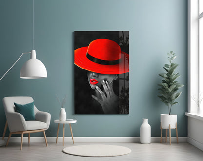 Scarlet Hat Glass Wall Art displayed on pale blue wall above white armchair in modern living room setting with plants and pendant lamp.