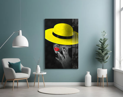 Yellow Hat Glass Wall Art displayed on teal wall above white chair in modern living room setting.