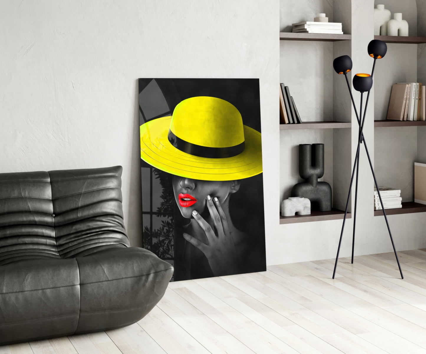 Yellow Hat Glass Wall Art displayed in modern living room with gray leather sofa, wooden shelving, and floor lamp.