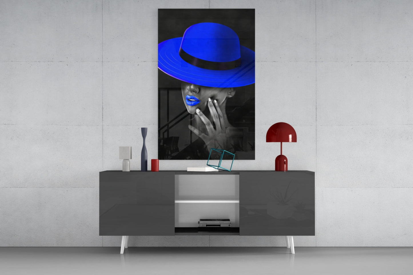Blue hat glass wall art displayed above a gray media console, showing a black and white portrait with vibrant blue accents.