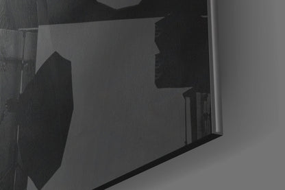 Close-up angled view of glass wall art showing silhouetted orange hat design through translucent glass panel.