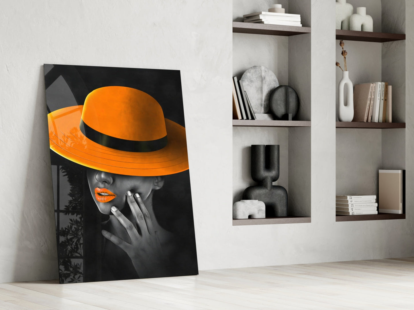 Orange Hat Glass Wall Art leaning against white wall beside shelving unit displaying decorative objects and books.