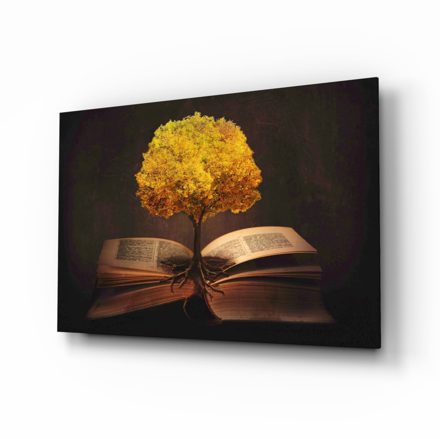 Glass wall art showing a golden tree with glowing foliage growing from an open book against dark background.