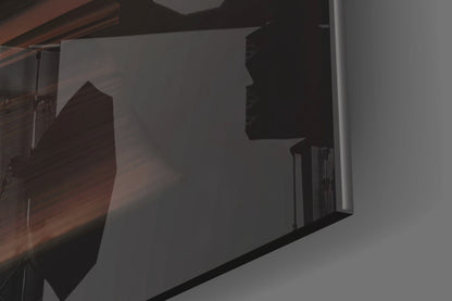 Close-up angled view of frosted glass wall art displaying dark silhouette of tree against translucent white surface with black frame edge visible.