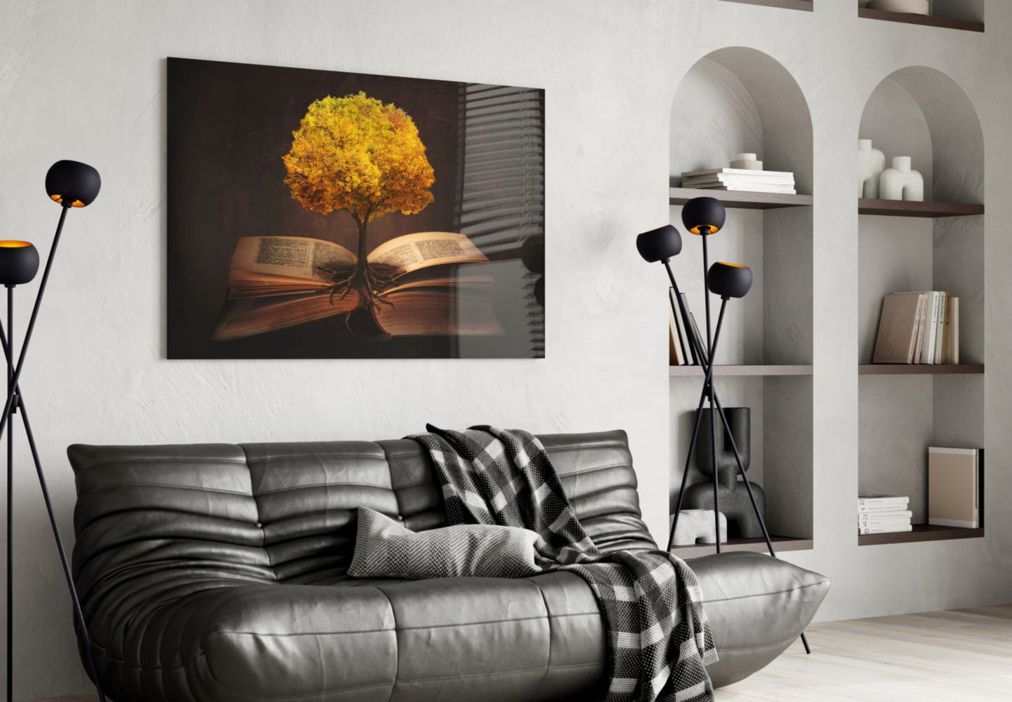 Glass wall art depicting golden tree growing from open book pages displayed above gray leather sofa in modern living room interior.
