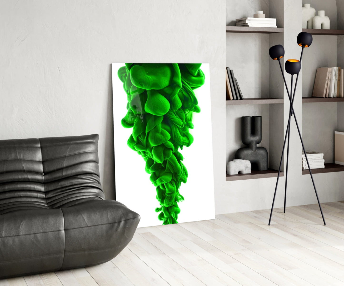 Green Layers Glass Wall Art leaning against white wall in modern living room with black sofa and shelving unit.