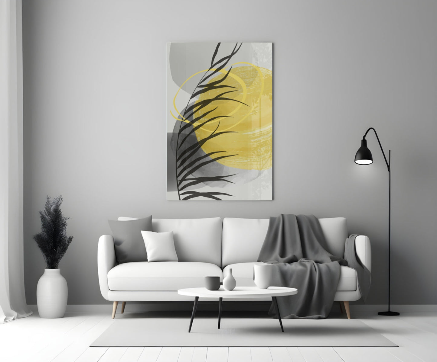 Modern living room with white sofa displaying yellow and black glass wall art above, accompanied by floor lamp and decorative vase.