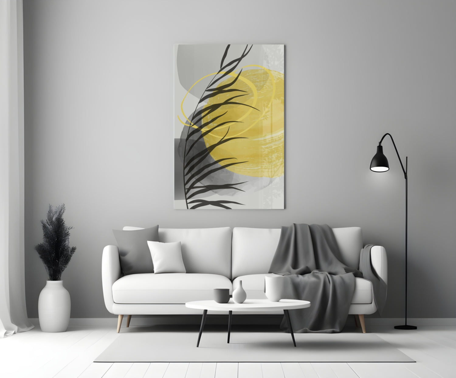 Modern living room with white sofa displaying yellow and black glass wall art above, accompanied by floor lamp and decorative vase.