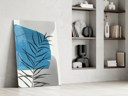 Modern minimalist interior with blue and grey abstract leaf canvas leaning against white wall beside built-in shelving.