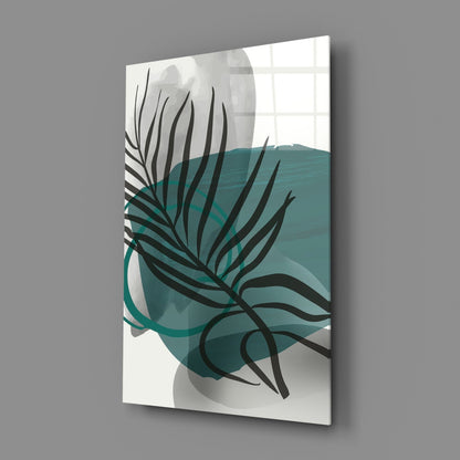 Angled perspective of glass wall art featuring black botanical lines and teal watercolor shapes on cream background.