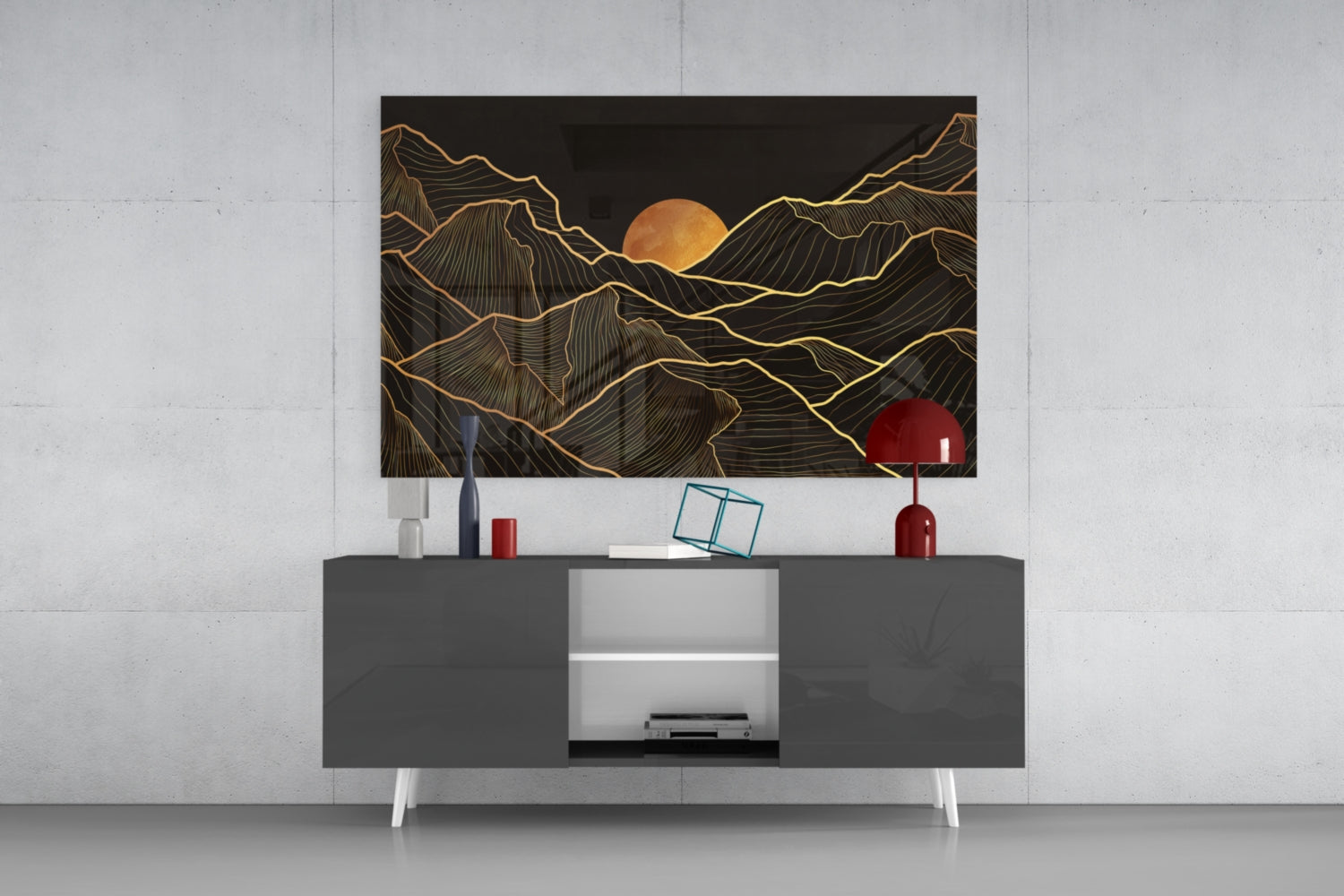 Black and gold mountain landscape glass art with full moon displayed above gray media console with white legs and red decorative accessories.