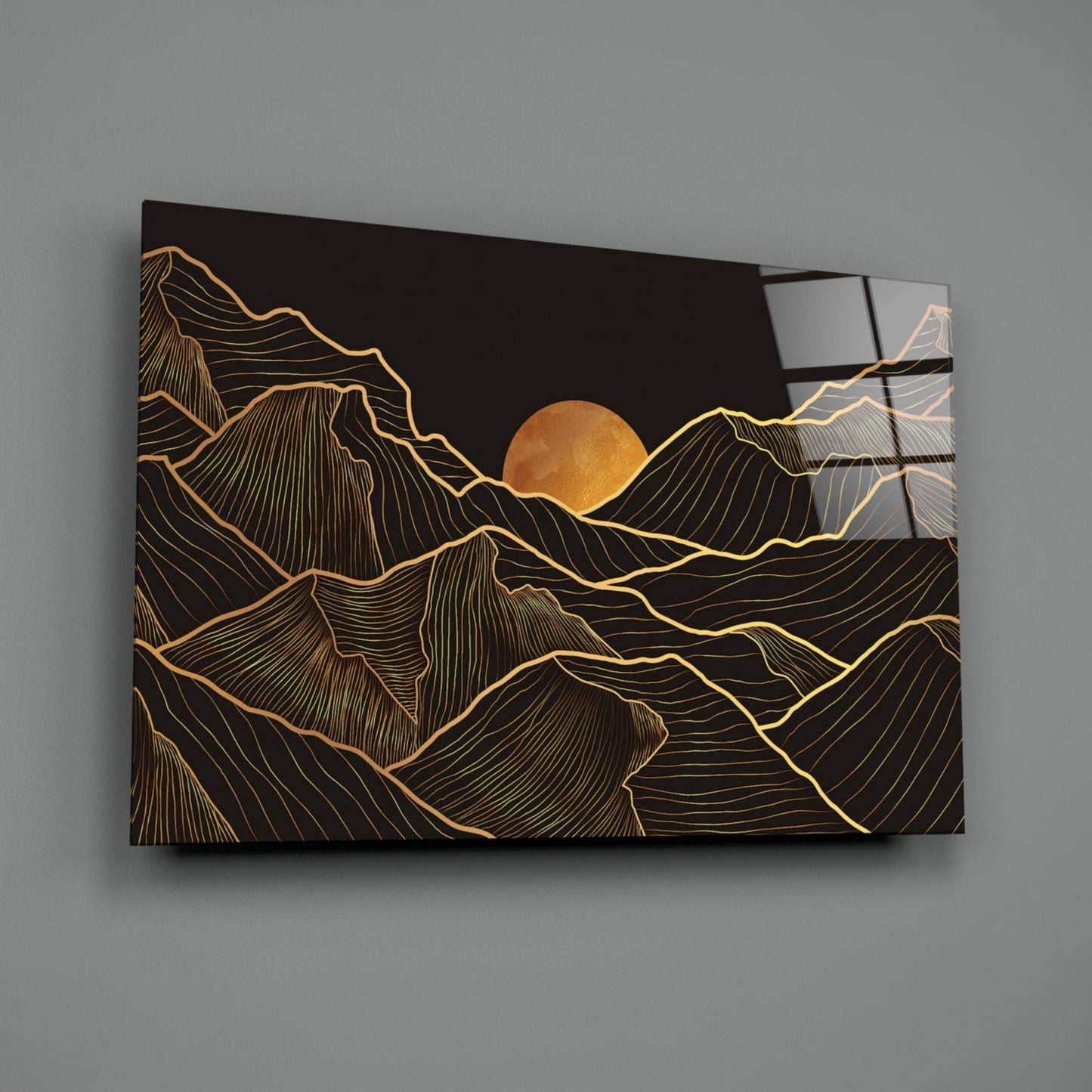 Black glass wall art with gold line-drawn mountains and full moon, displayed at an angle showing depth and reflective surface.