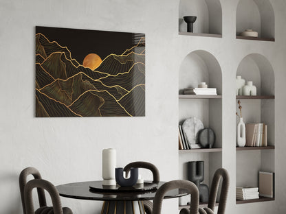 Black and gold glass wall art depicting mountains with a golden sun, displayed above a round dining table in a modern interior.