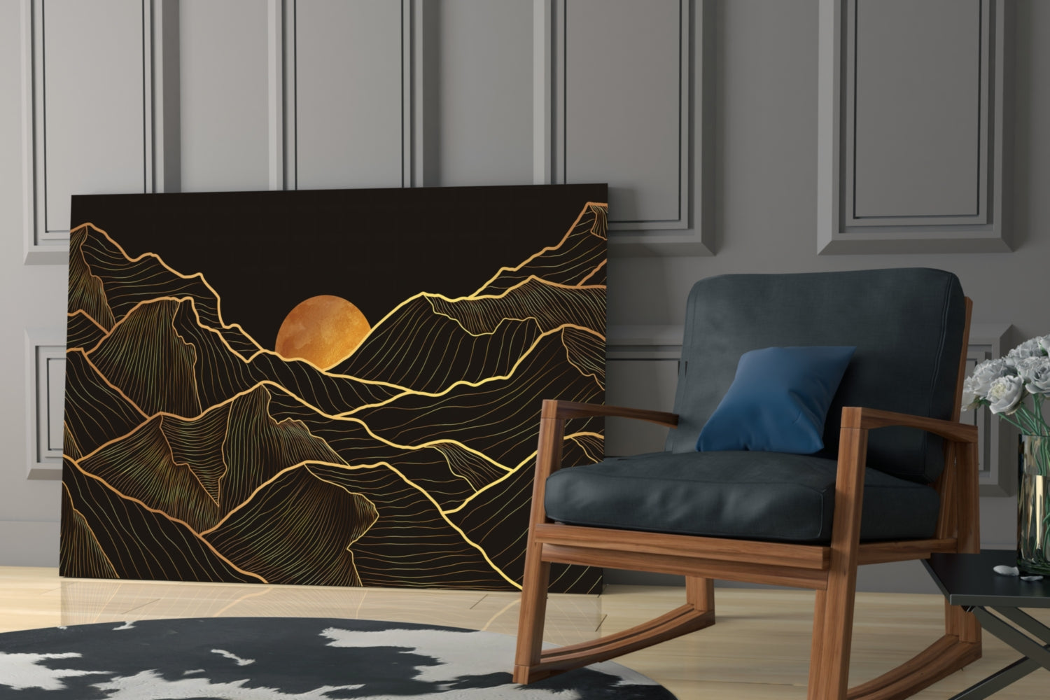 Black glass wall art with gold line-drawn mountains and orange sun, displayed in modern living room beside wooden chair.