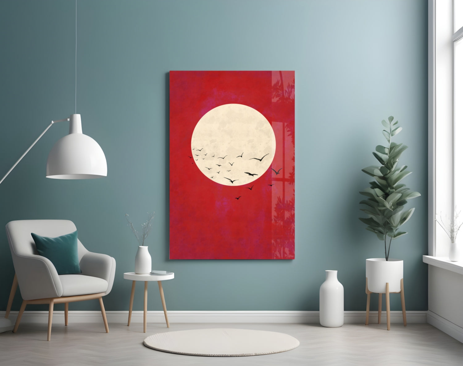 Red glass wall art featuring a cream moon with flying birds, displayed in a modern living room with teal walls and contemporary furniture.